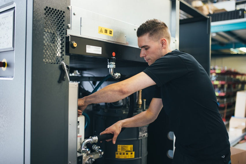 Ein Servicetechniker führt eine Kompressor Wartung in der Nähe durch.